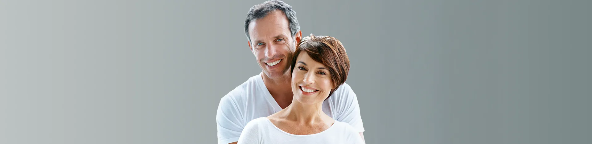 Smiling couple showcasing confidence and happiness, representing the positive impact of dental health and treatments like Hybridge dental implants.